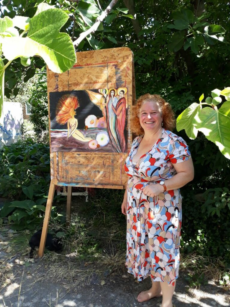 la peintre Anne-Claire Boshâ dans son jardin à Esperaza devant l'un de ses tableaux à l'aquarelle intitulé touché par la grâce